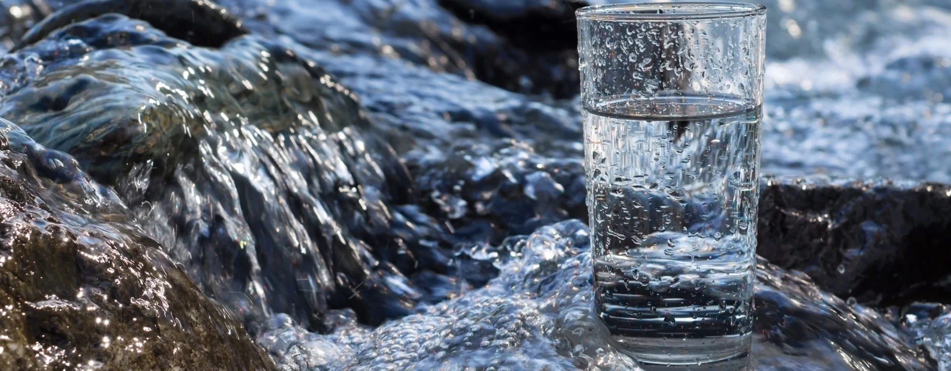 szklanka wody na tle rzeki
